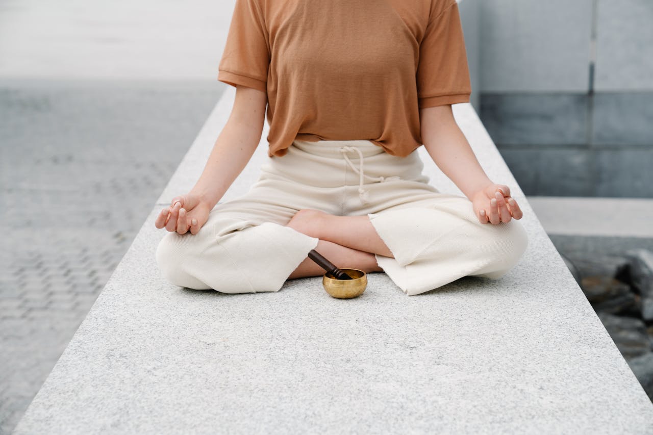 A person meditating outdoors with a singing bowl, embracing serenity and mindfulness.