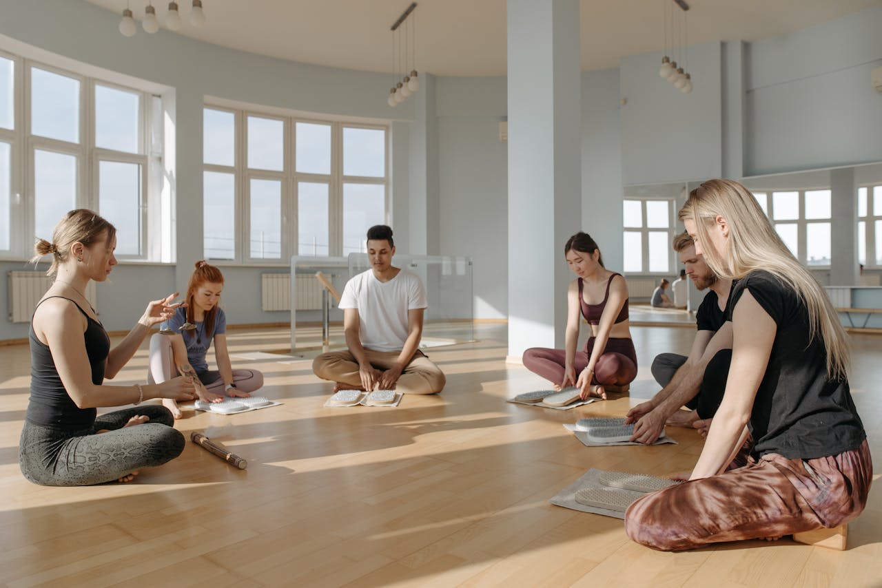 A diverse group of people meditating together indoors, creating a serene and peaceful environment.